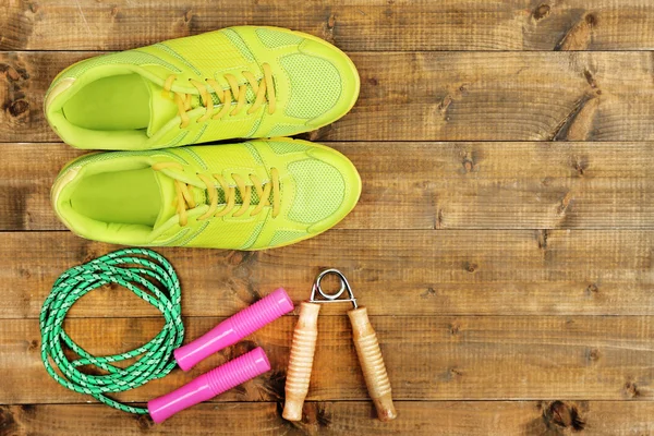 Schoenen en sport apparatuur op houten vloer, bovenaanzicht — Stockfoto