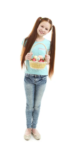Красива дівчинка тримає плетений кошик з великодніми яйцями, ізольовані на білому — стокове фото