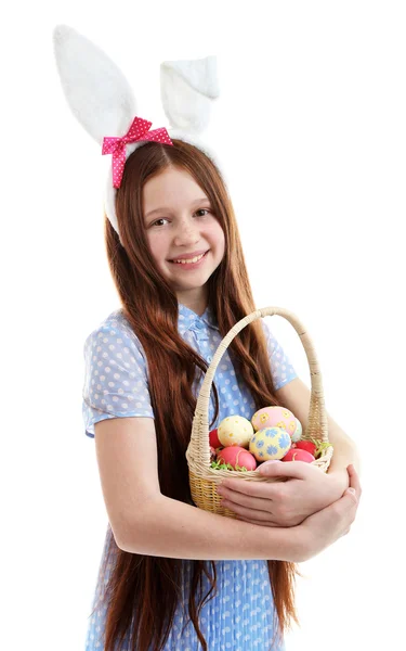 Schönes kleines Mädchen mit Osterhasenohren und Weidenkorb mit Ostereiern, isoliert auf weiß — Stockfoto