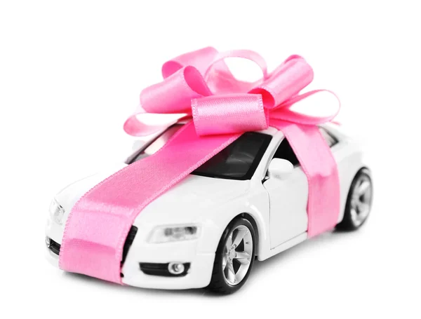 Nowy samochód z różowy bow jako biały na białym tle na obecny — Zdjęcie stockowe