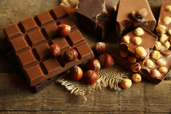 Still life with set of chocolate with nuts on wooden table, closeup — Stock Fotó