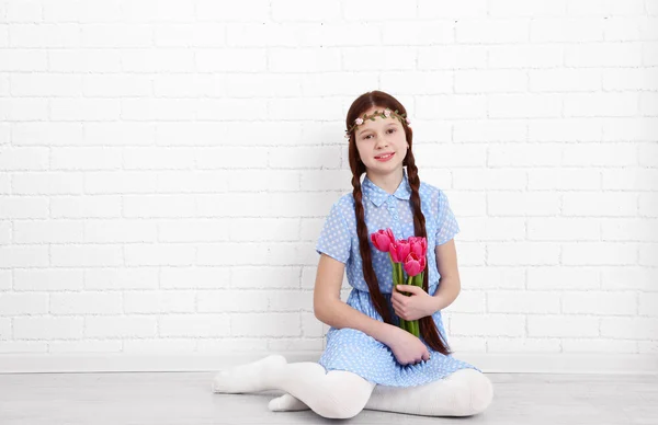 Beautiful little girl on bricks wall background — Stock Photo, Image