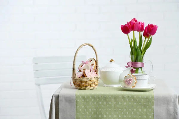 Teservis med blommor på bordet, på ljus bakgrund — Stockfoto