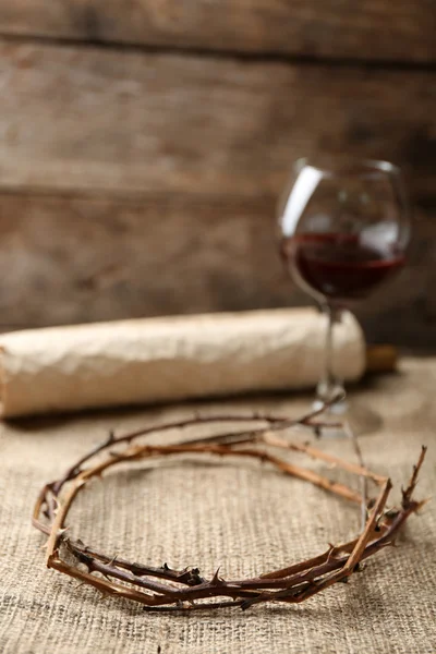 Kroon van doornen, schuiven en glas wijn op oude houten achtergrond — Stockfoto