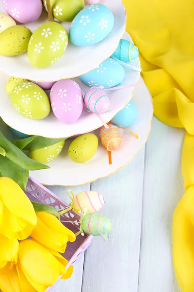 Huevos de Pascua en jarrón y tulipanes en mesa de primer plano —  Fotos de Stock