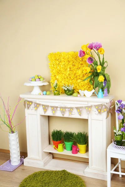 Chimenea con hermosas decoraciones de primavera en la habitación — Foto de Stock