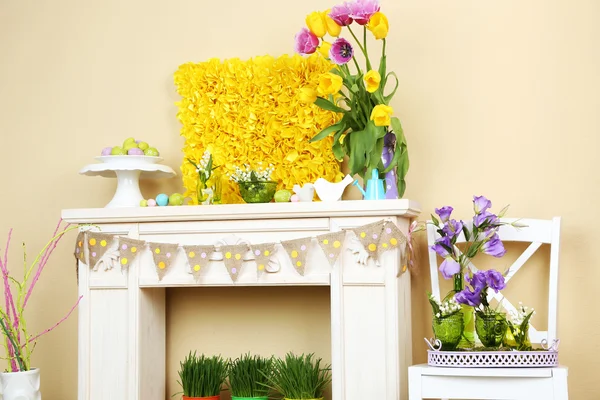 Fireplace with beautiful spring decorations in room — Stock Photo, Image