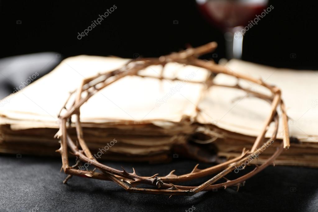 Crown of thorns and old bible on black background