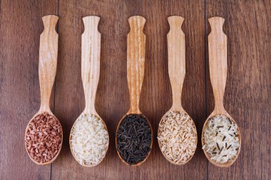 Ahşap zemin üzerine kaşık pirinç çeşitleri