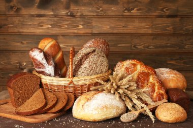 Different bread with ears and sunflower seeds on wooden background clipart