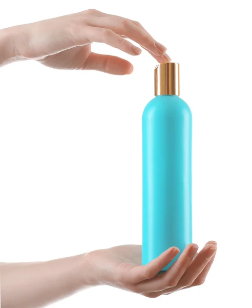 Mãos femininas com garrafa de cosméticos isolados em branco — Fotografia de Stock