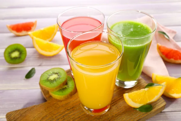 Fresh juices with fruits on wooden table — Stock Photo, Image