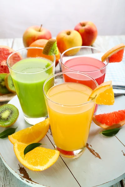 Fresh juices with fruits on wooden table — Stock Photo, Image