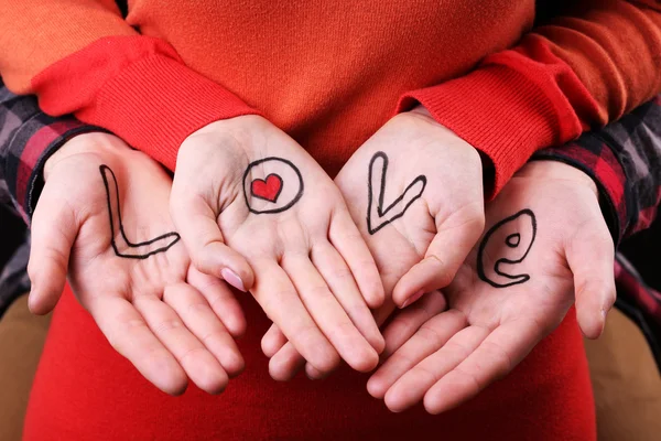 Hands of couple with inscription Love, close-up view — Stock Photo, Image