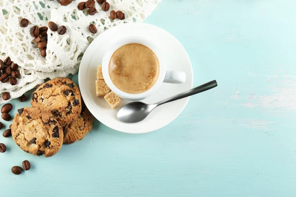Tasse Kaffee und leckeres Gebäck auf farbigem Holzhintergrund — Stockfoto