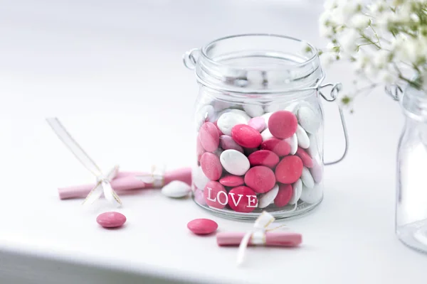 Dolci caramelle in vaso con fiori su sfondo davanzale — Foto Stock