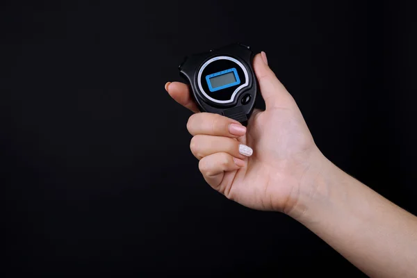 Electronic sport timer in  female hand on black background — Stock Photo, Image