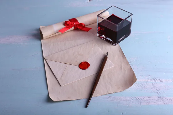 Enveloppe avec stylo et encre sur fond en bois — Photo