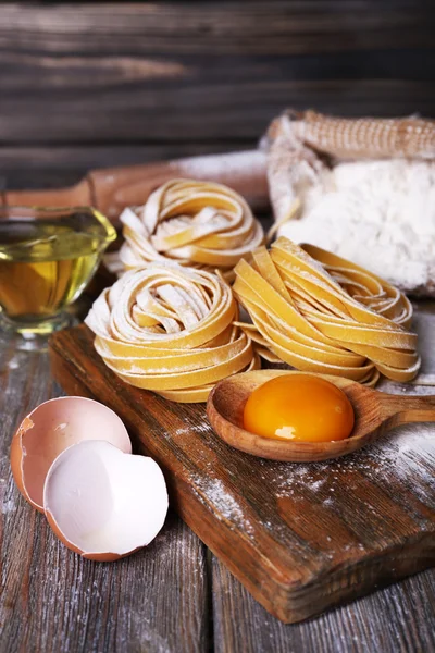 Сирі домашні макарони та інгредієнти для макаронних виробів на дерев'яному фоні — стокове фото