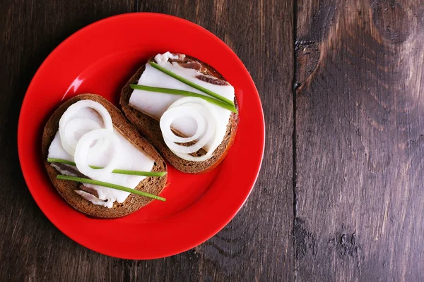 ラードと木製の背景に皿に玉ねぎのサンドイッチ — ストック写真