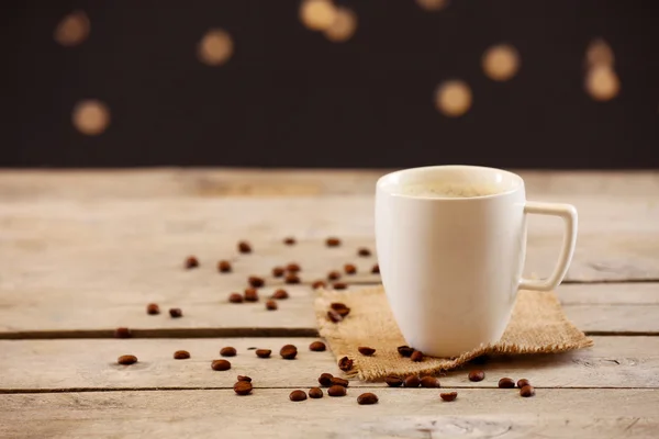 Tasse Kaffee auf Tisch auf braunem Hintergrund — Stockfoto