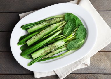 Yeşil salata salatalık ve ahşap masa, closeup üzerinde yabani pırasa ile