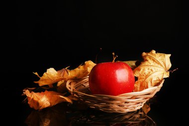 Siyah arka plan üzerine kurutulmuş hasır sepet içinde elma
