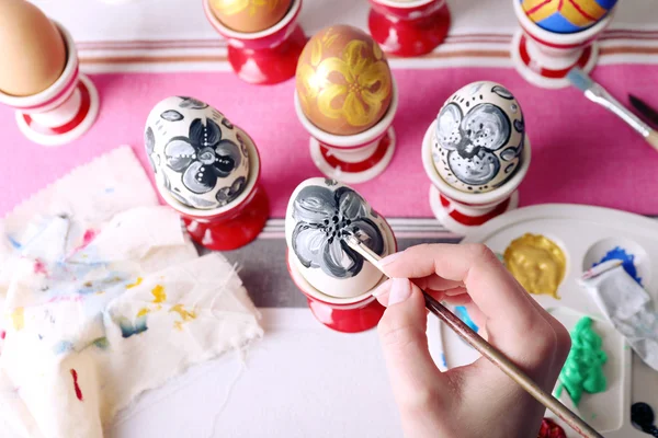 Young woman painting Easter eggs on table close up — Stock Photo, Image