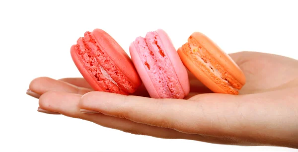 Macaroons coloridos saborosos na mão feminina isolada em branco — Fotografia de Stock