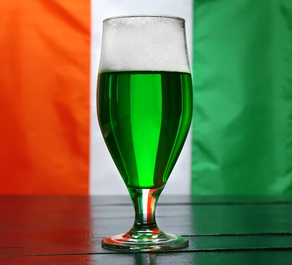 Vaso de cerveza verde sobre fondo de bandera de Irlanda — Foto de Stock
