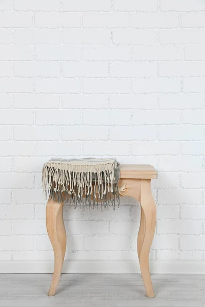 Wooden chair with plaid on white brick wall background — Stock Photo, Image