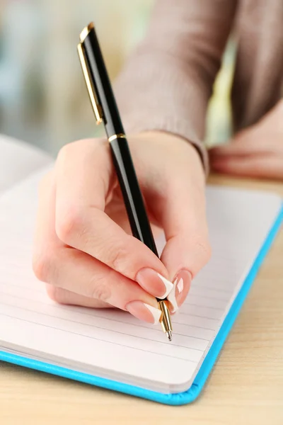 Mano femenina con bolígrafo escrito en cuaderno, primer plano — Foto de Stock