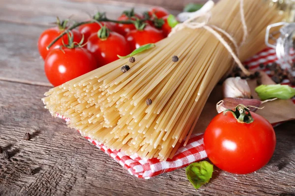 Pasta with cherry tomatoes and other ingredients on wooden table background — Stock Photo, Image