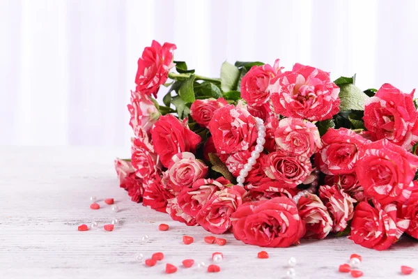 Красивые розы на столе на светлом фоне — стоковое фото
