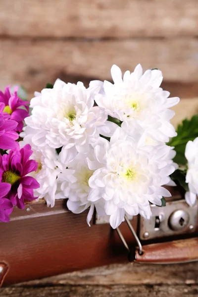 Eski tahta bavul ve ahşap arka plan üzerinde çiçekler — Stok fotoğraf