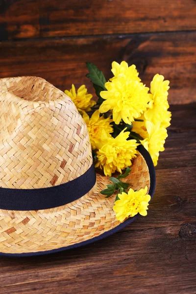 Hut mit Blumen auf Holzgrund — Stockfoto