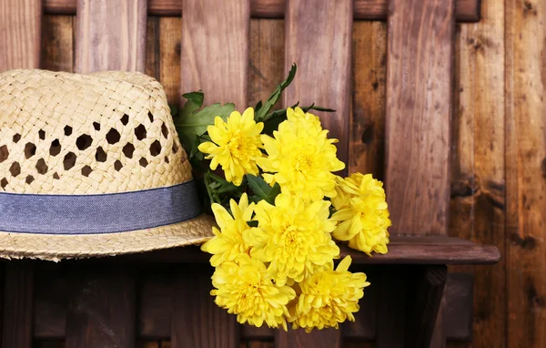 Chapeau avec des fleurs sur fond en bois — Photo