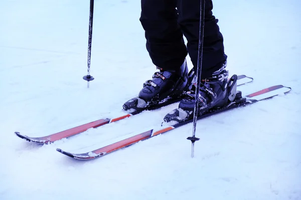 Mänskliga ben med skidor över vit snö bakgrund — Stockfoto