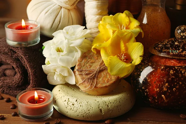 Composizione del trattamento termale, candela e fiori su sfondo tavolo in legno — Foto Stock