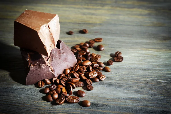 Barras de chocolate con granos de café sobre fondo de madera —  Fotos de Stock