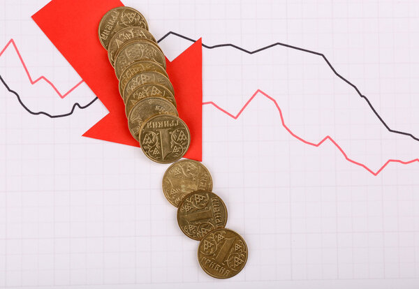 Coins and red arrow on graph document close up