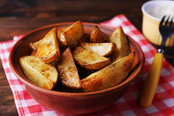 Gebakken aardappelen in kom en saus op tafel close-up — Stockfoto