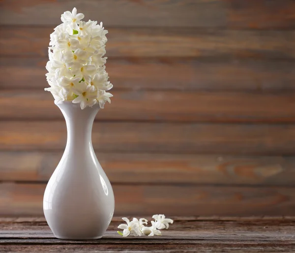 Vacker vit hyacint blomma i vasen på bordet på trä bakgrund — Stockfoto