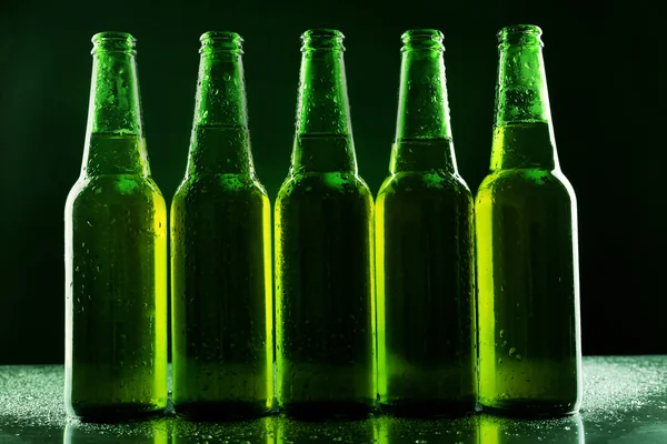 Bottiglie di vetro di birra su sfondo scuro — Foto Stock