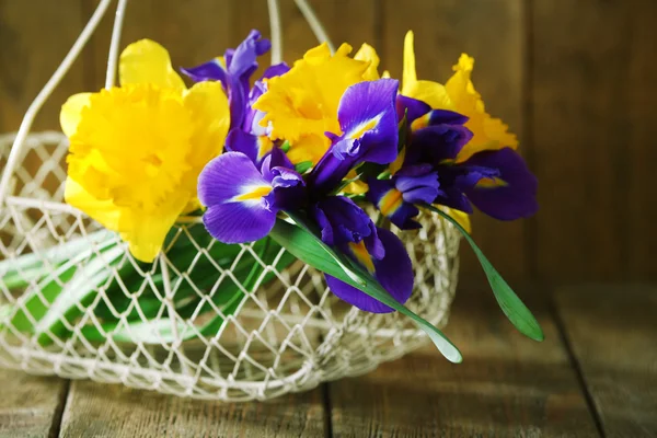 Belles fleurs de printemps en osier panier métallique sur fond en bois — Photo