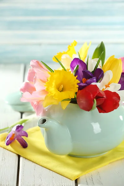 Красиві весняні квіти на дерев'яному столі на синьому фоні — стокове фото