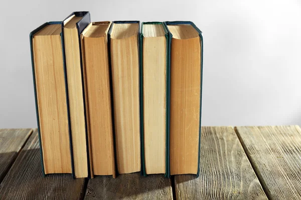 Gamla böcker på träbord på grå bakgrund — Stockfoto