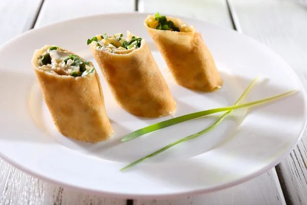 Pannenkoeken met room, kaas en Groenen in plaat op houten tafel, close-up — Stockfoto