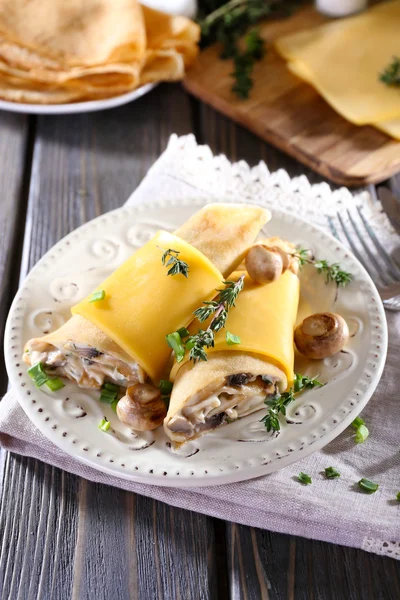 Pfannkuchen mit cremigen Pilzen im Teller auf Holztisch, Nahaufnahme — Stockfoto