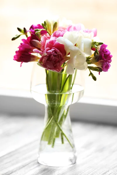 Vackra vårblommor i vas på fönsterkarmen bakgrund — Stockfoto